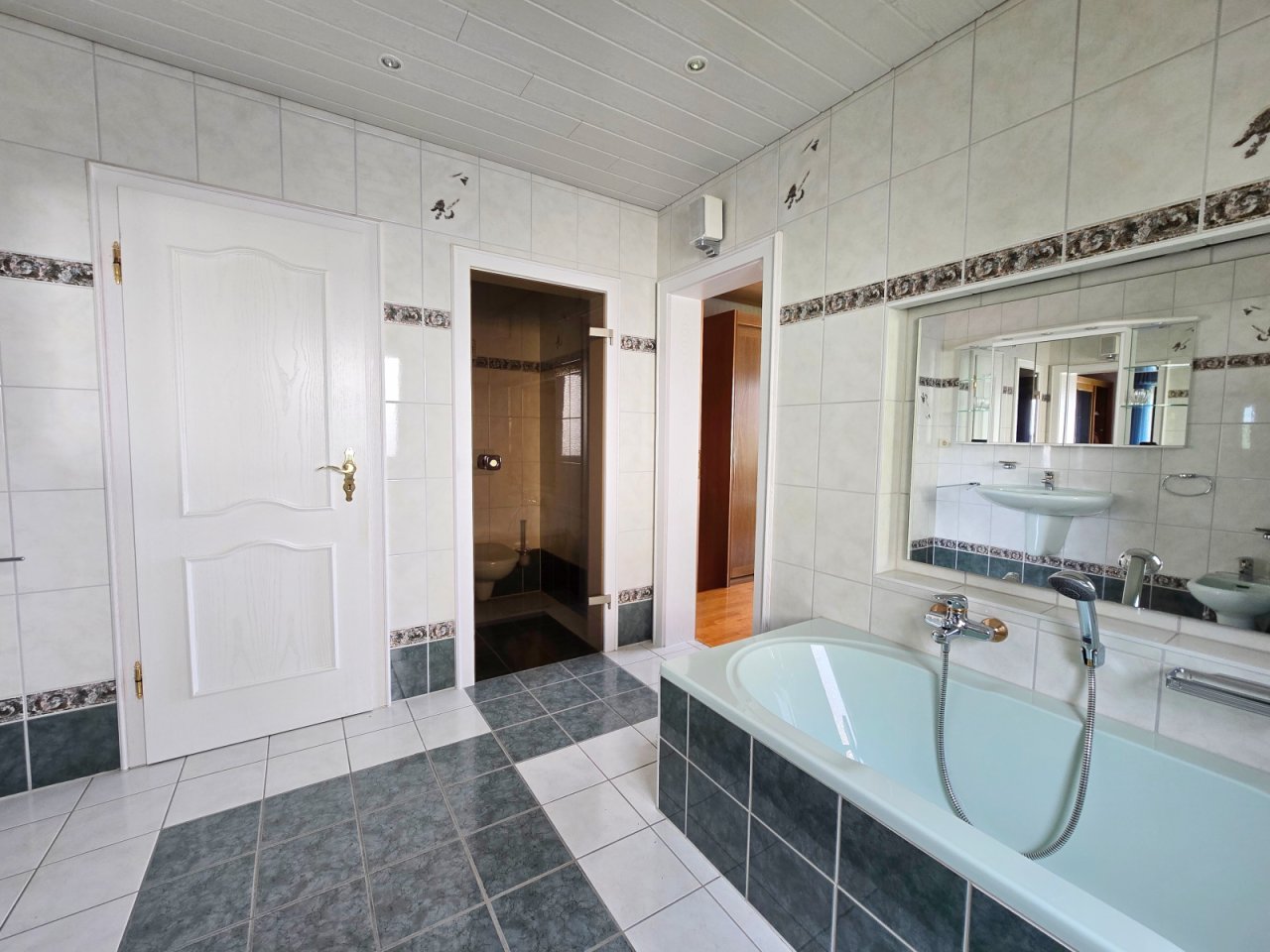 Hauptbad mit elegant abgetrenntem WC und Zugang zum Schlafzimmer
