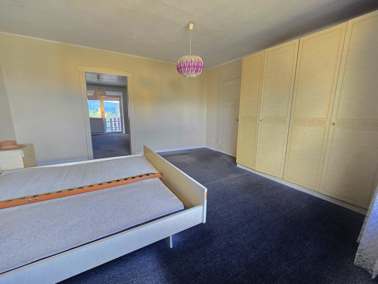 Schlafzimmer mit roßem Kleiderschrank ud Blick zu Ankleide bzw
