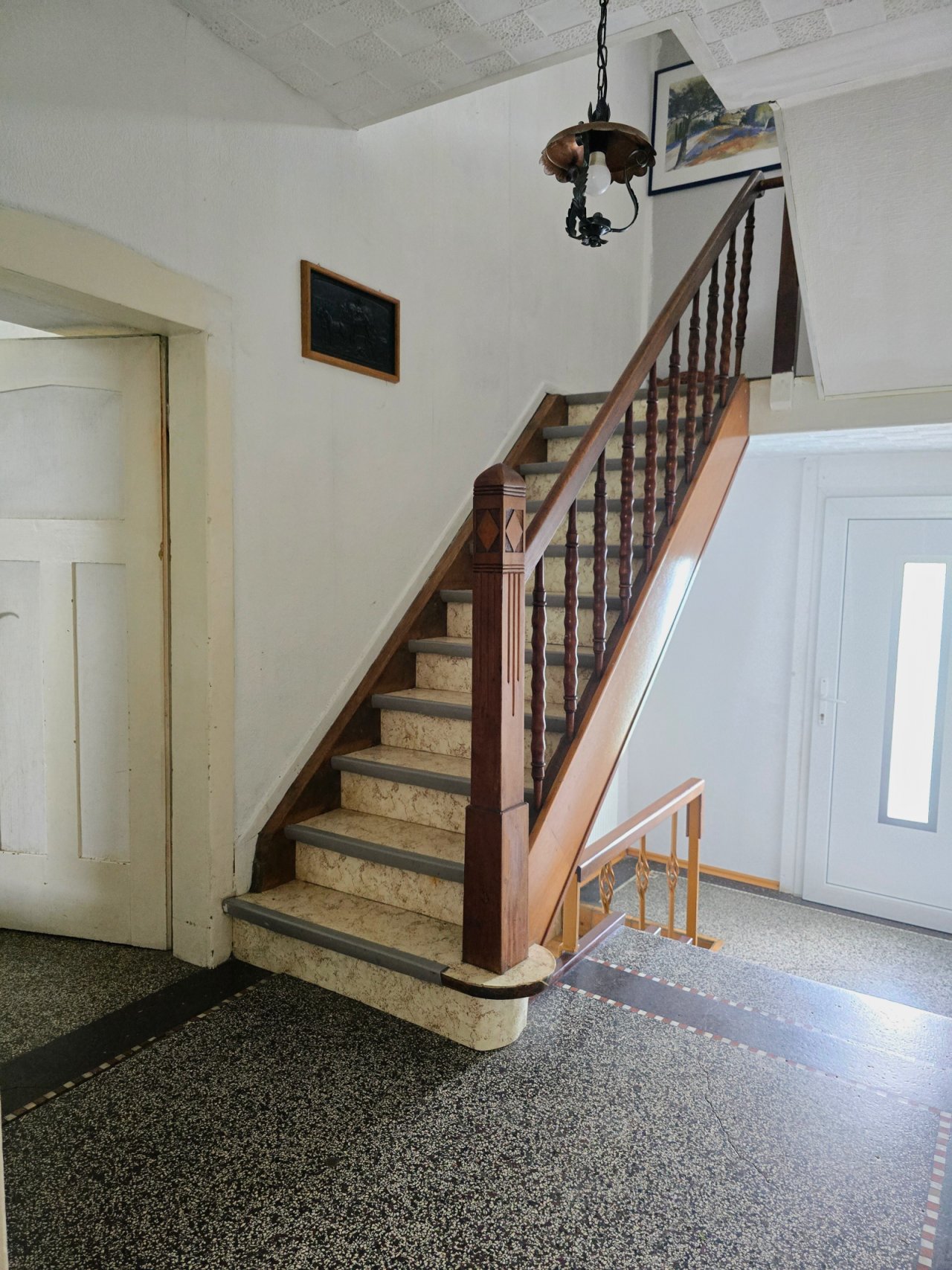 Hauseingang mit original Holztreppe und Terrazzo-Boden