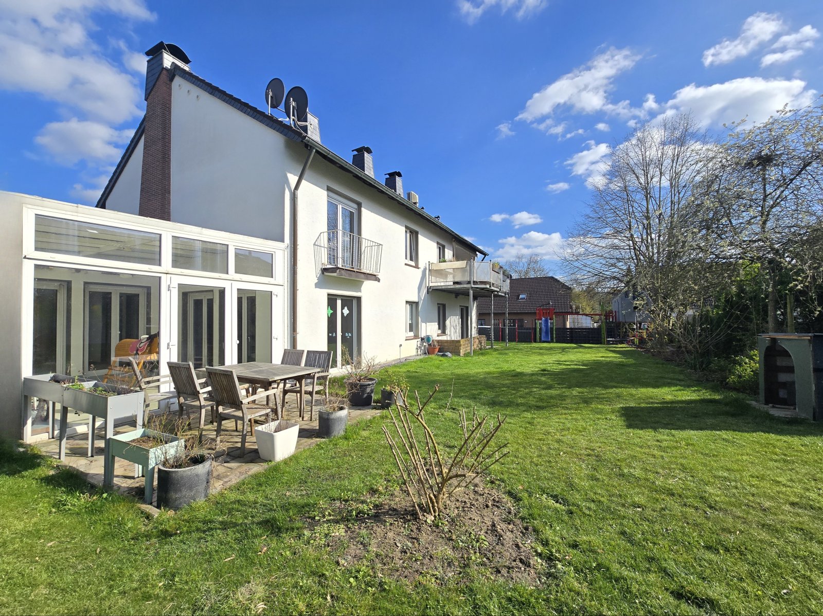 Rückseite mit Wintergarten, Terrasse und Balkon